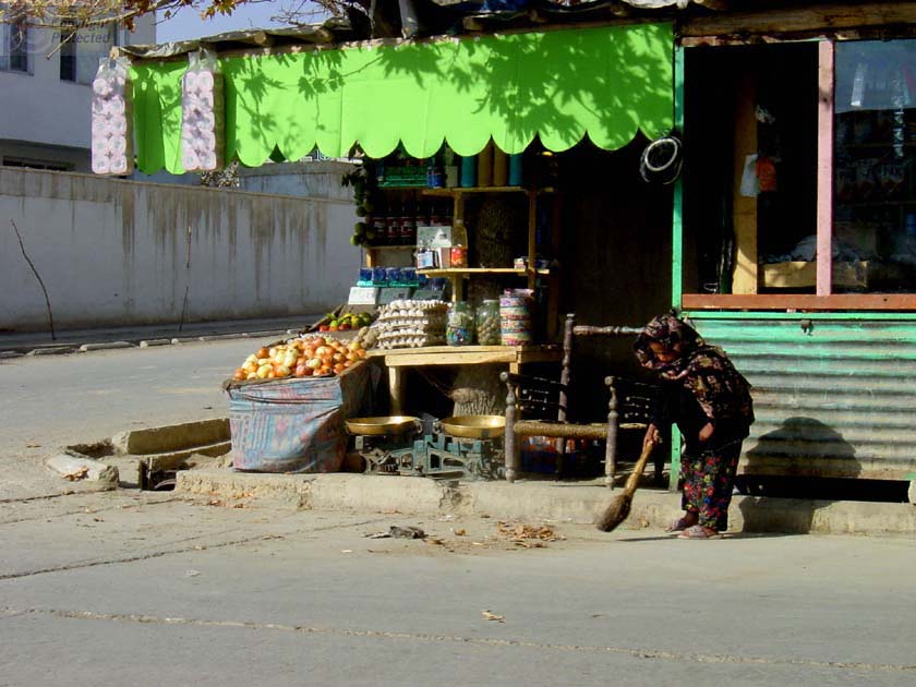 Little Girl sweeping in front of Shop 